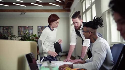 Group Of Young Businesspeople Talking In Office, Start-Up Concept.