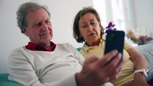 Senior Couple Relaxing at Home with a Smartphone