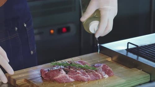 Chef Prepares Seasoned Steak on Wooden Board