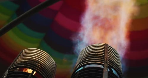 Slow motion close up view of the flame inside of a colorful hot air balloon being inflated before