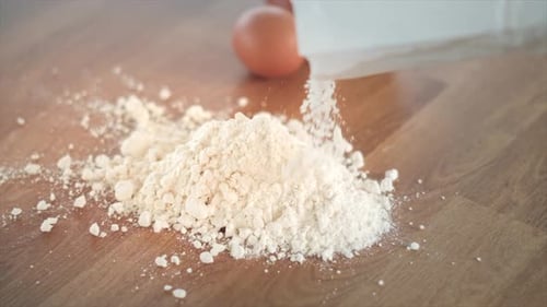 Pouring Flour on a Wooden Table With Eggs