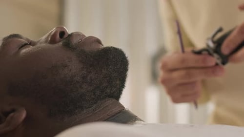 Man getting nose hair trimmed at barber