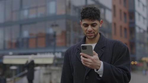 Man Cheers at Good News on Cell Phone