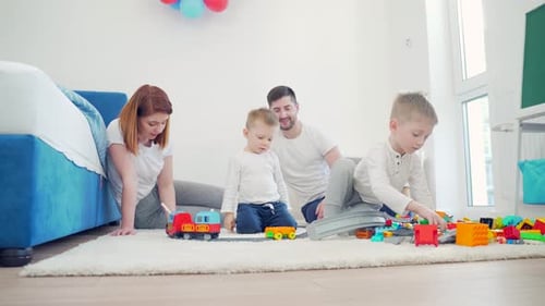 Junges glückliches Ehepaar mit kleinen Kindern verbringt die Freizeit zusammen zu Hause. Familie mit zwei