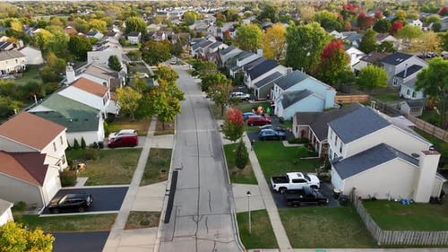 Aerial View of Suburban Street in Autumn Vibrant Homes and Trees Along Quiet Roads