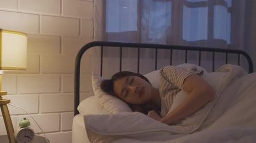 Asian beautiful woman lying down on bed in bedroom, dreaming at night.