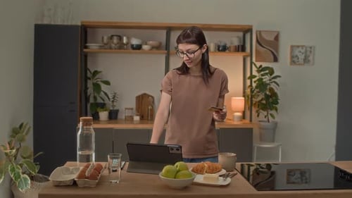Woman using tablet and credit card in kitchen