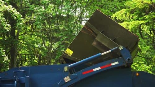 Garbage bin being emptied in blue garbage truck - close up