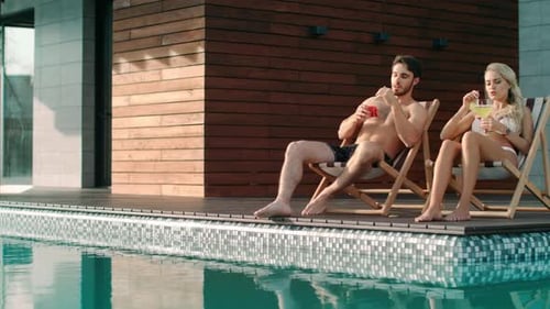 Love Couple Relaxing on Sun Chairs Near Pool at Luxury House. Closeup