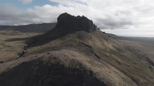 Aerial flying above west Iceland, towards spectacular mountain summit
