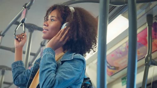 Young Woman Listening to Music on Train