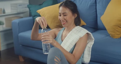 Woman Hydrating After Workout in Home Living Room