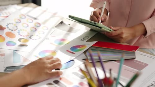 Slow motion hand closeup of two designer choosing color in office. Variegated