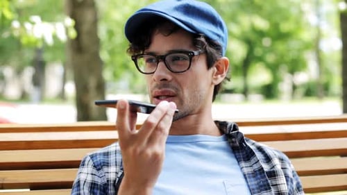 Hispanic man in city street chatting on speakerphone with mobile technology