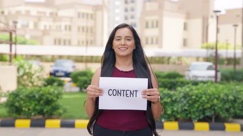 Young Woman Holds a Sign in an Urban Setting