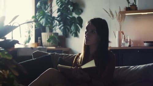 Woman Reading Book on Couch Indoors