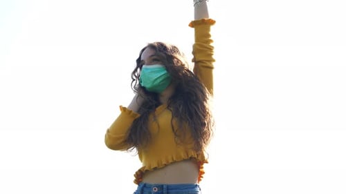 Young Woman Dancing Outside Wearing a Face Mask