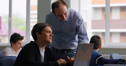 Clases de programación para niños y adolescentes Profesor y alumno discutiendo el Código del Programa