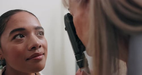 Woman, optometrist and checkup for vision, health and eye care with retinoscope test