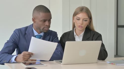 Ständiger afrikanischer Geschäftsmann hilft weiblichen Angestellten bei der Arbeit