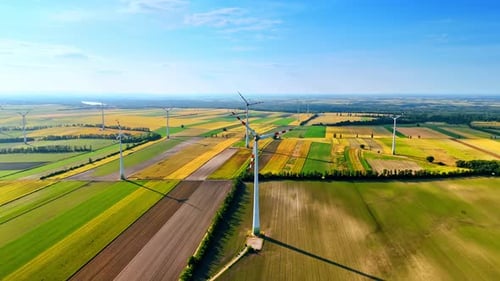 Wind Turbines Spinning in Green and Yellow Fields