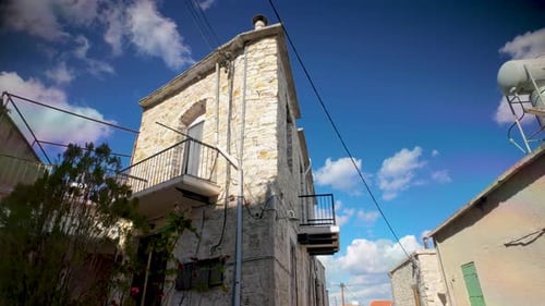 Une grande maison traditionnelle en pierre avec des balcons et un ciel bleu en toile de fond. Une prouesse architecturale historique