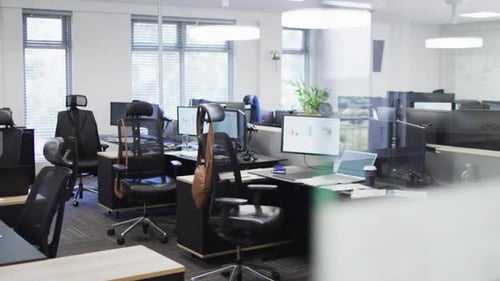 General view of empty modern office with multiple computers, slow motion