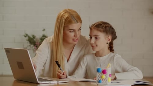 Woman Helping a Child With Homework and Laptop