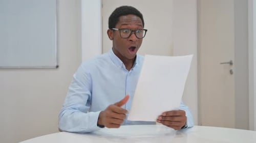 Man Reading Document Receives Good News and Celebrates