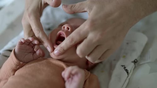 Bebê, cuidados de saúde e as mãos de um pediatra no hospital durante um check-up ou consulta