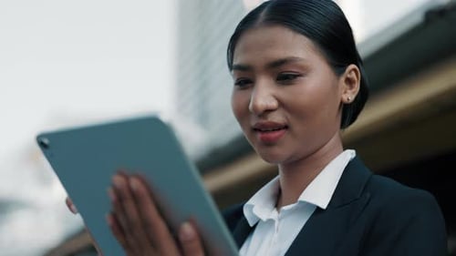 Woman Using Tablet Outside in Urban Setting