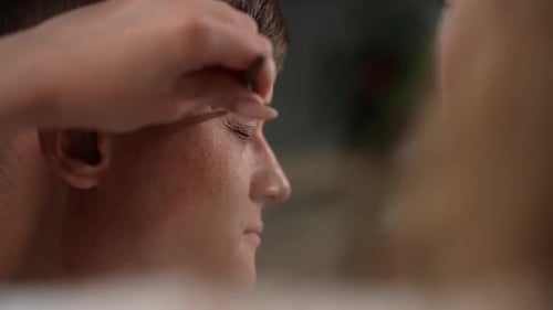 Closeup Hands of Unrecognizable Beautician Using Tweezers to Shape Eyebrows of Client Male in Beauty