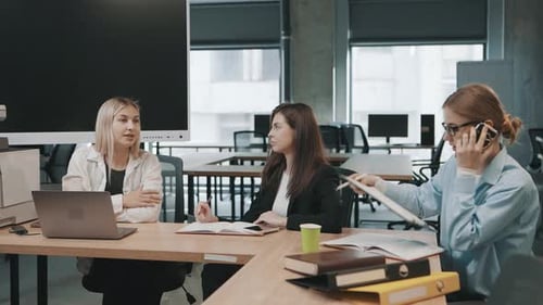 Business team collaborates on project in modern office setting while discussing important documents