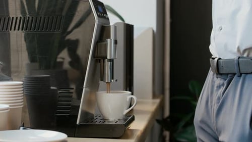 Anonymous Black Male Manager Waiting for Coffee by Machine in Office