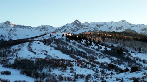 Panorama de gauche à droite en haut d'une colline herbeuse révélant la chaîne de Sawatch au coucher du soleil