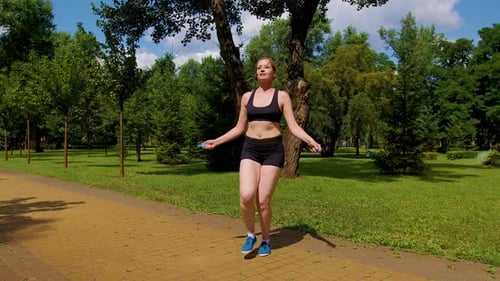 Lovely Active Sporty Fit Woman Doing Jump Rope Cardio Workout in Park
