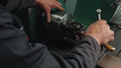Man Adjusts Metal Working Machine