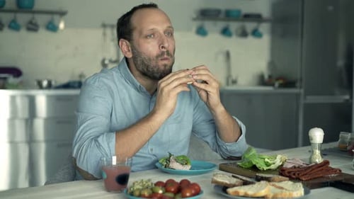 Man Eating Sandwich at Kitchen Table Lunch