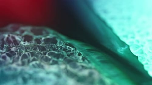 Nahaufnahme lebendiger Tinte, die im Wasser verteilt und ein faszinierendes abstraktes Muster erzeugt