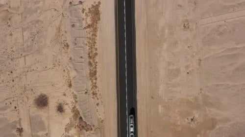 Cars driving on a Desert road surrounded by dry land, Aerial view