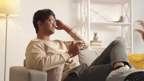 Young Adult Relaxing with Coffee in Modern Home