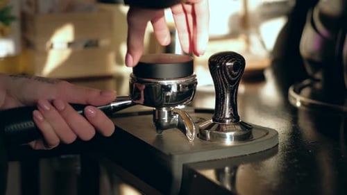 Prozess der Kaffeezubereitung. Baristas Hände mit Stöpfern.