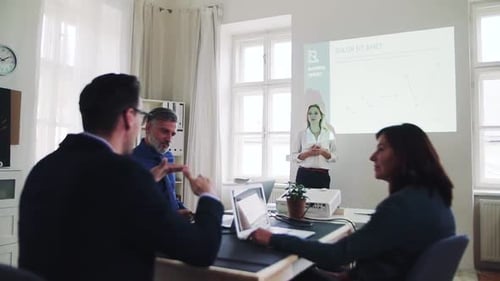 Businesswoman leads engaging presentation for colleagues in modern office