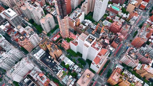 Dense urban landscape with green streets. Drone flight over the lively cityscape of modern New York