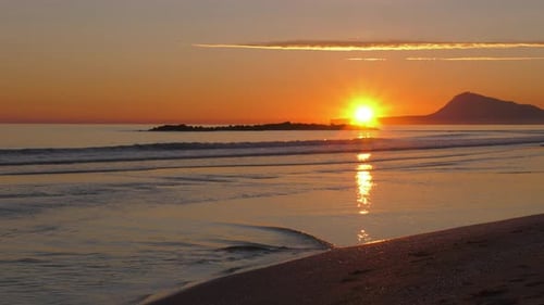 Sunrise beach, Slow motion waves on sandy shore, calm ripples in shallow water, mediterranean, spain