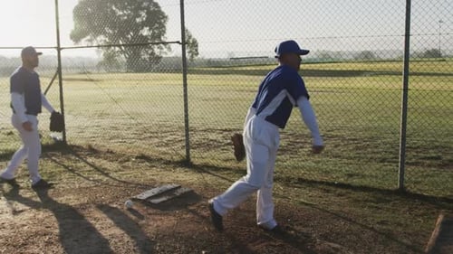 Playing baseball, pitcher preparing to throw ball while teammate watches