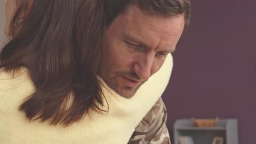 Man in Military Uniform Hugging a Woman