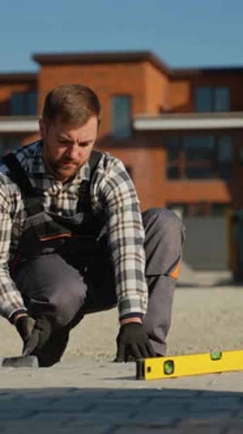 Man Laying Bricks for Walkway Construction