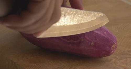 Fresh Purple Yam being Sliced on Cutting Board