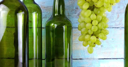 Grapes and wine bottles on blue vintage wooden background.